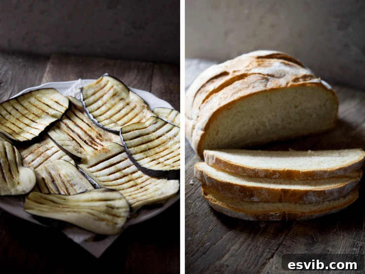 Grilled eggplant with char marks on a plate next to a sliced loaf of crusty bread. Eggplant bruschetta with mozzarella