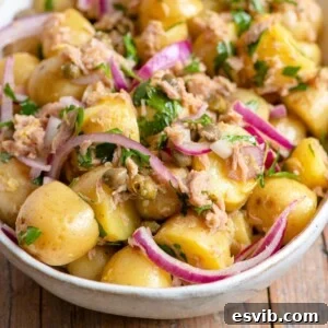 A close up of a tuna potato salad in a bowl, ready to serve.