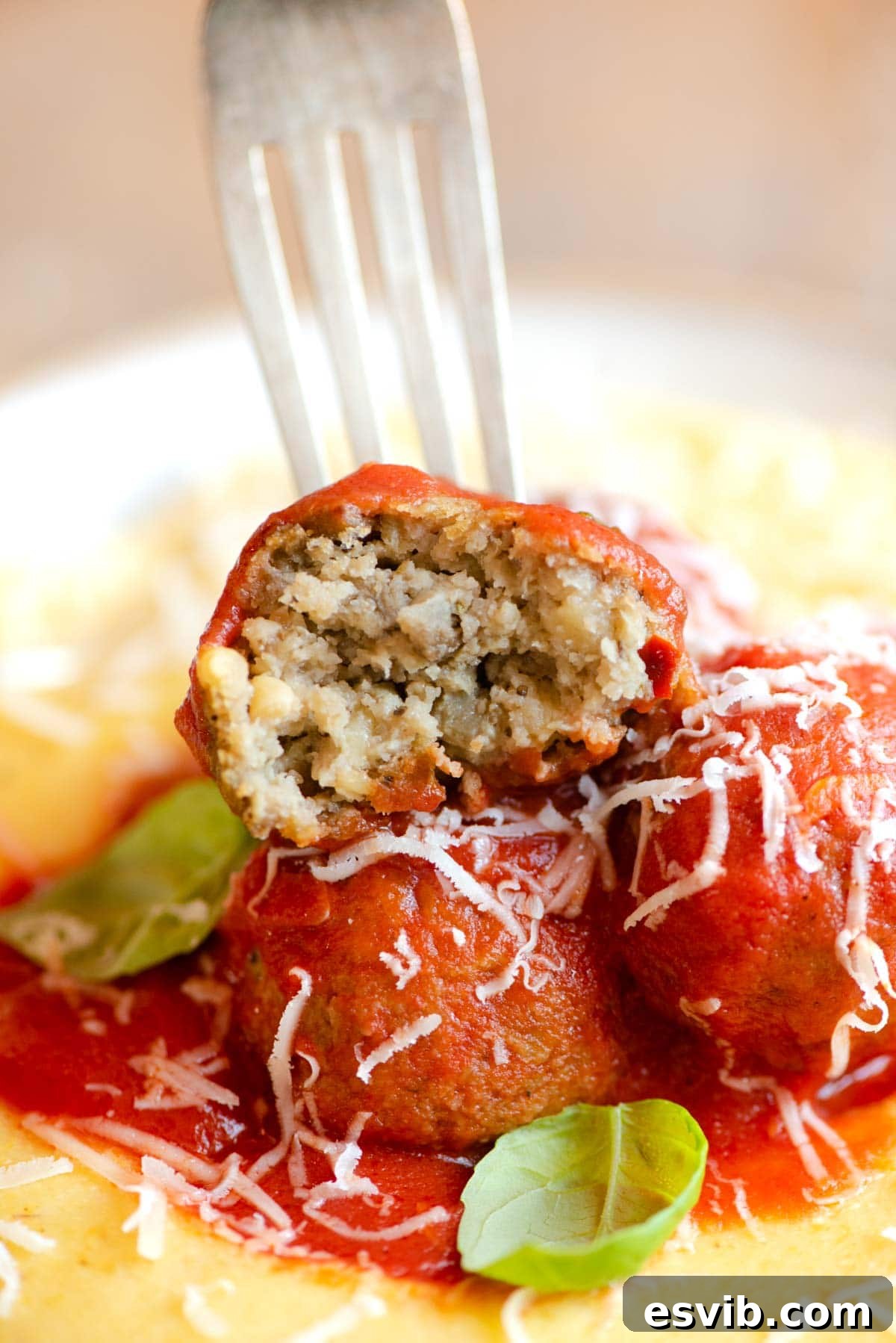 Plant-Based Eggplant Meatballs in Rustic Tomato Sauce 7 A close up of an eggplant meatball cut in half, revealing its textured interior.