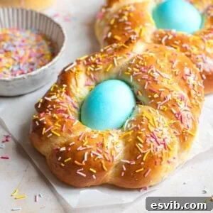 A close up of Italian Easter bread with sprinkles and a blue egg in the middle