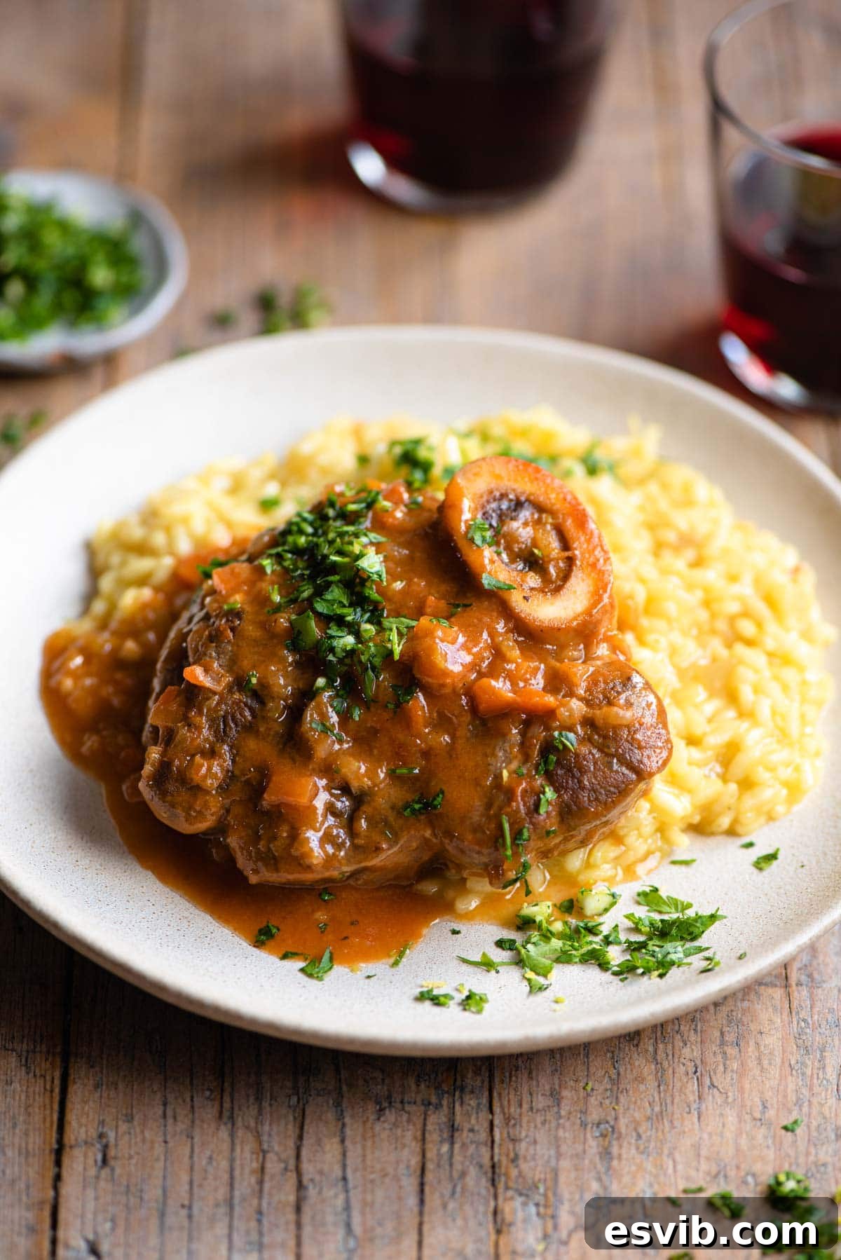 Osso Bucco on a plate of saffron risotto and topped with gremolata