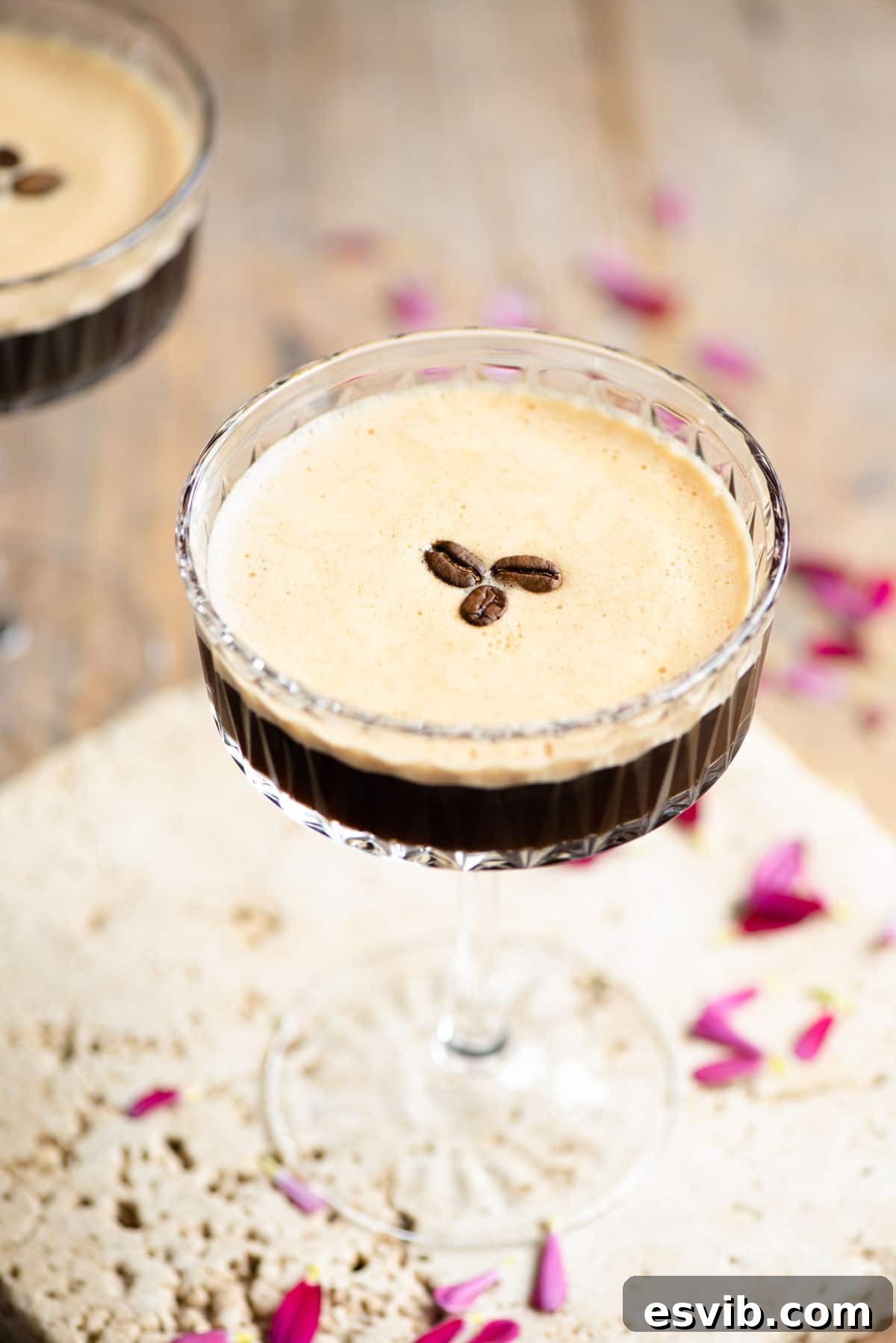 An elegantly presented Espresso Martini, garnished with three perfect coffee beans on its creamy, foamy top, ready to be enjoyed.