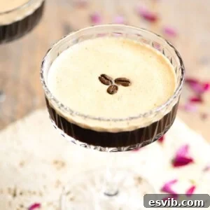 A close up of an espresso martini topped with coffee beans, illustrating the creamy foam and elegant garnish.