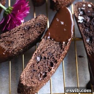 A close up of freshly baked Triple Chocolate Biscotti, showing the crunchy texture and rich chocolate coating.