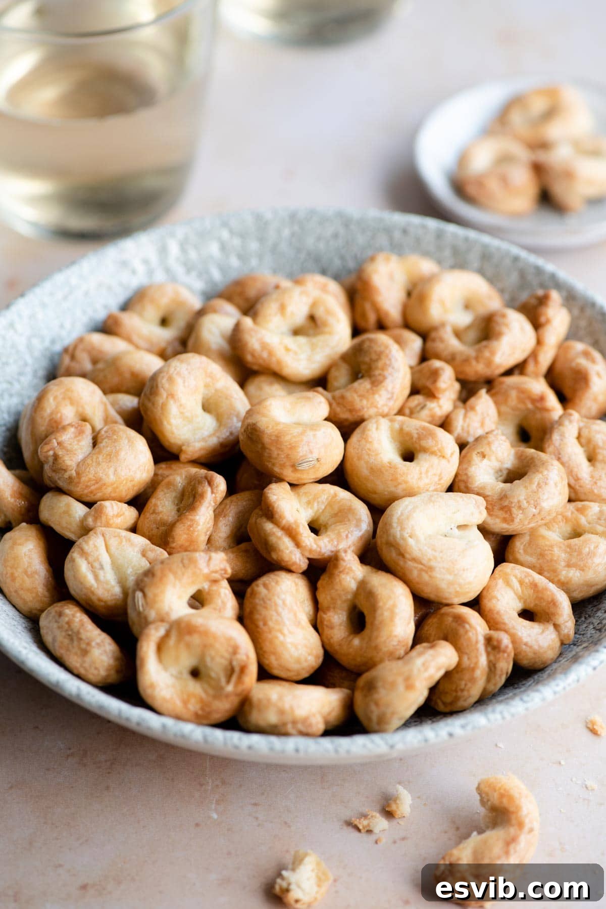Puglian Taralli Italy's Crunchy Snack Rings 7 A side shot of a rustic ceramic bowl brimming with beautifully golden-brown Italian taralli, perfectly arranged and ready for serving at an Italian gathering.