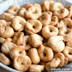 A close up of taralli in a bowl, showing their golden crisp texture and inviting appeal