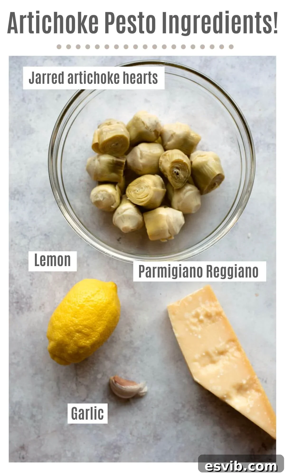 An overhead shot of labelled ingredients needed to make artichoke pesto; jarred artichoke hearts, lemon, Parmigiano Reggiano and garlic, and a bottle of olive oil.