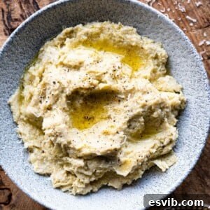 A close-up square image of artichoke pesto in a bowl, ready to serve.