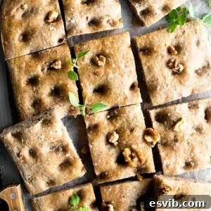 A close up of a walnut focaccia cut into squares