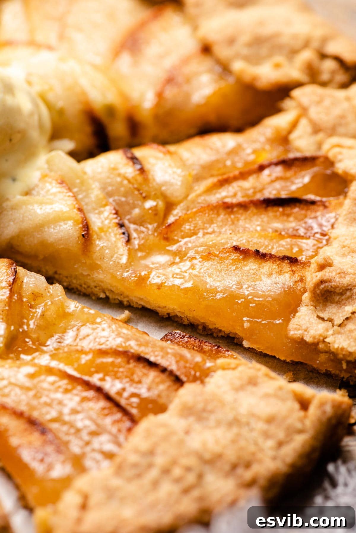 A close up of a slice of apple crostata with apricot jam, showcasing the texture and filling