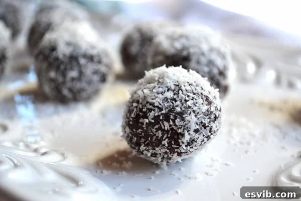 Close-up of a dark chocolate avocado truffle with coconut flakes.