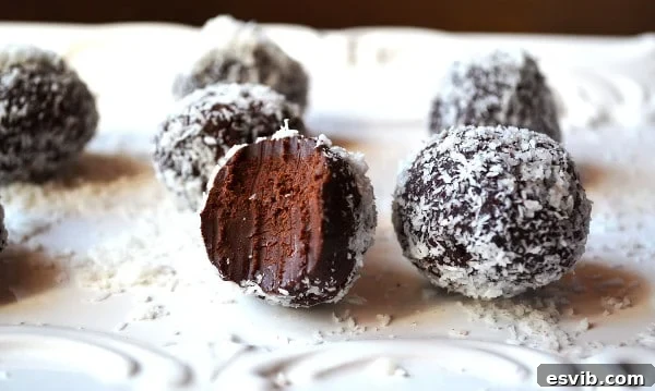 A selection of dark chocolate avocado truffles, some coated in coconut, others in cocoa powder.