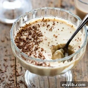 A close up of Bailey's panna cotta in a small glass bowl with a spoon in it