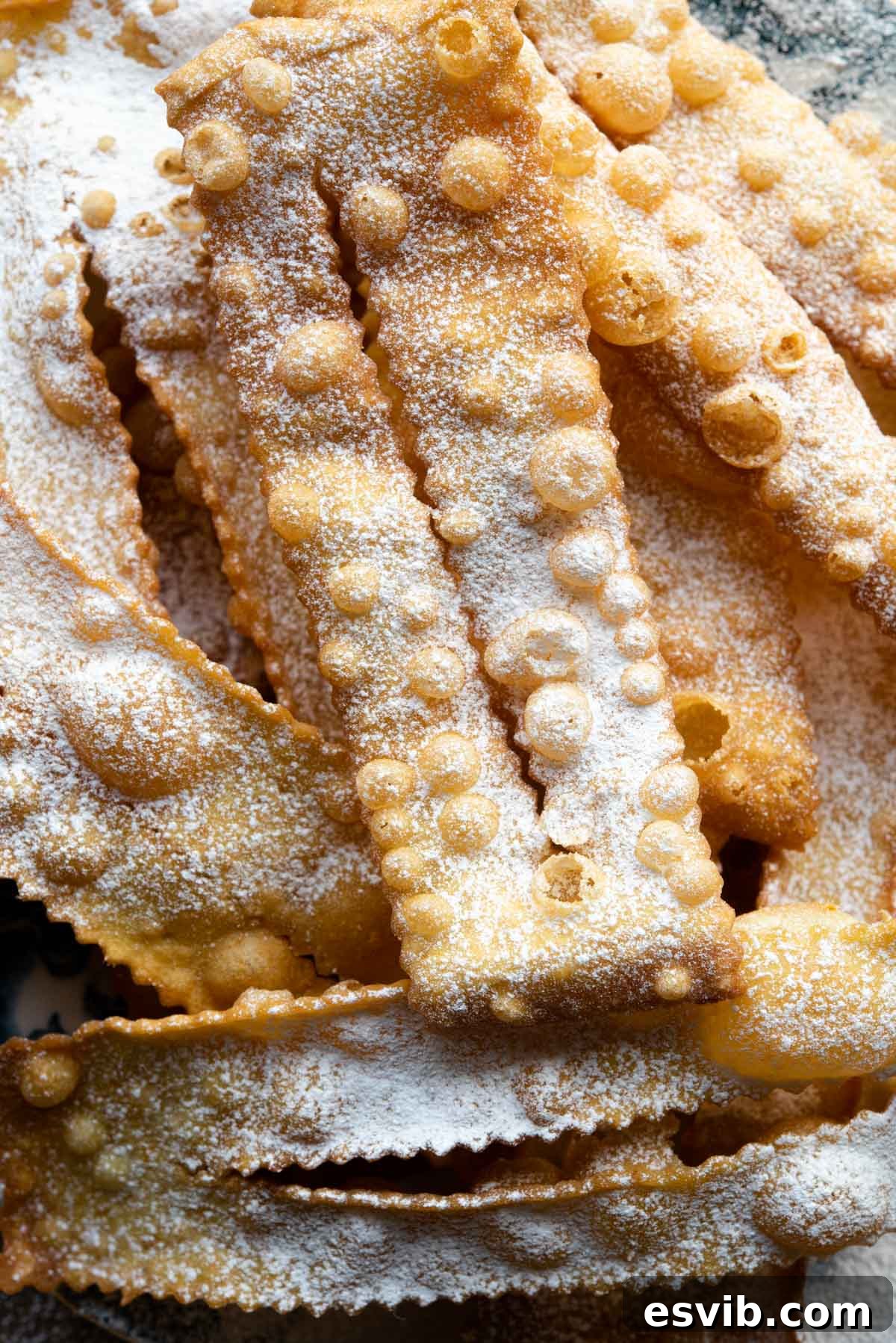 Italian Carnival Ribbons: Golden Fried Delights 8 A close up shot of a perfectly fried Italian pastry, Cenci, dusted generously in powdered sugar, ready for serving.