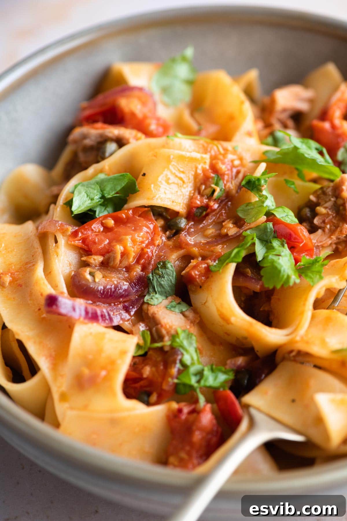 Quick Tuna Tomato and Caper Pasta 6 A close up of pappardelle pasta with tuna, tomatoes, onion and capers