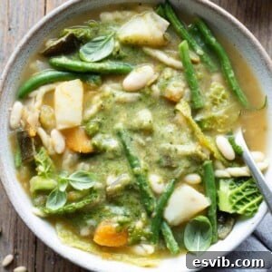 A close up of Ligurian minestrone soup in a bowl with pesto on top, ready to serve and enjoy.