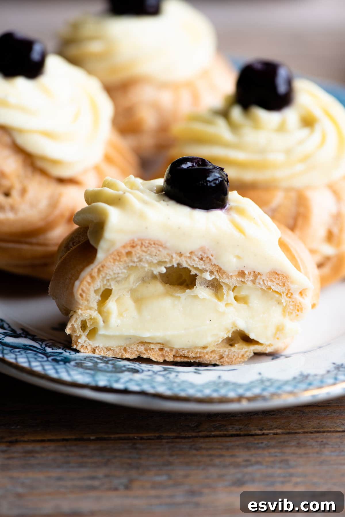 St Josephs Day Sweet Tradition 9 A close up of an Italian pastry, Zeppola di San Giuseppe, artfully cut in half to reveal its luscious pastry cream filling, resting on an elegant blue plate.