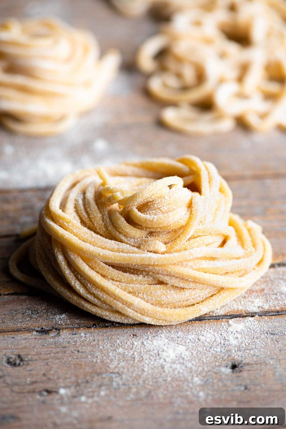 Homemade Tonnarelli Pasta 2 A nest of tonnarelli pasta sitting on a wooden surface, ready to be cooked or stored.