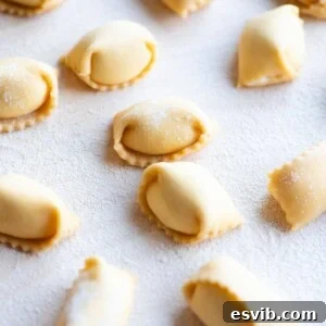A close up cropped image of homemade Agnolotti on a wooden board.