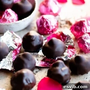 Homemade Italian Chocolate Kisses 7 A close-up cropped image of homemade Baci chocolates elegantly presented in pink foils on a stylish travertine worktop.
