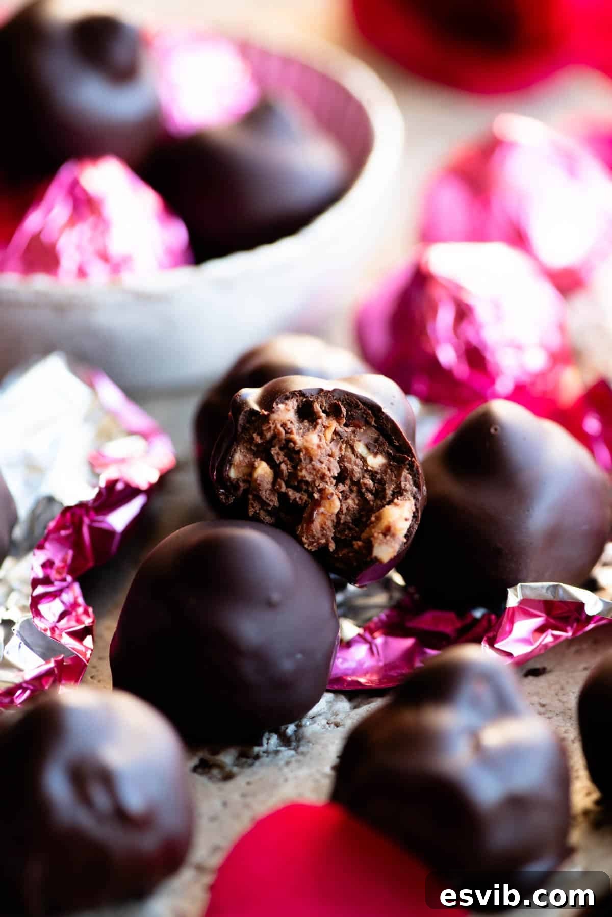 Homemade Italian Chocolate Kisses 6 A tantalizing close-up of a perfectly crafted homemade Italian Baci chocolate, elegantly bitten in half, revealing its lusciously creamy milk chocolate hazelnut center and the crunchy whole hazelnut within.