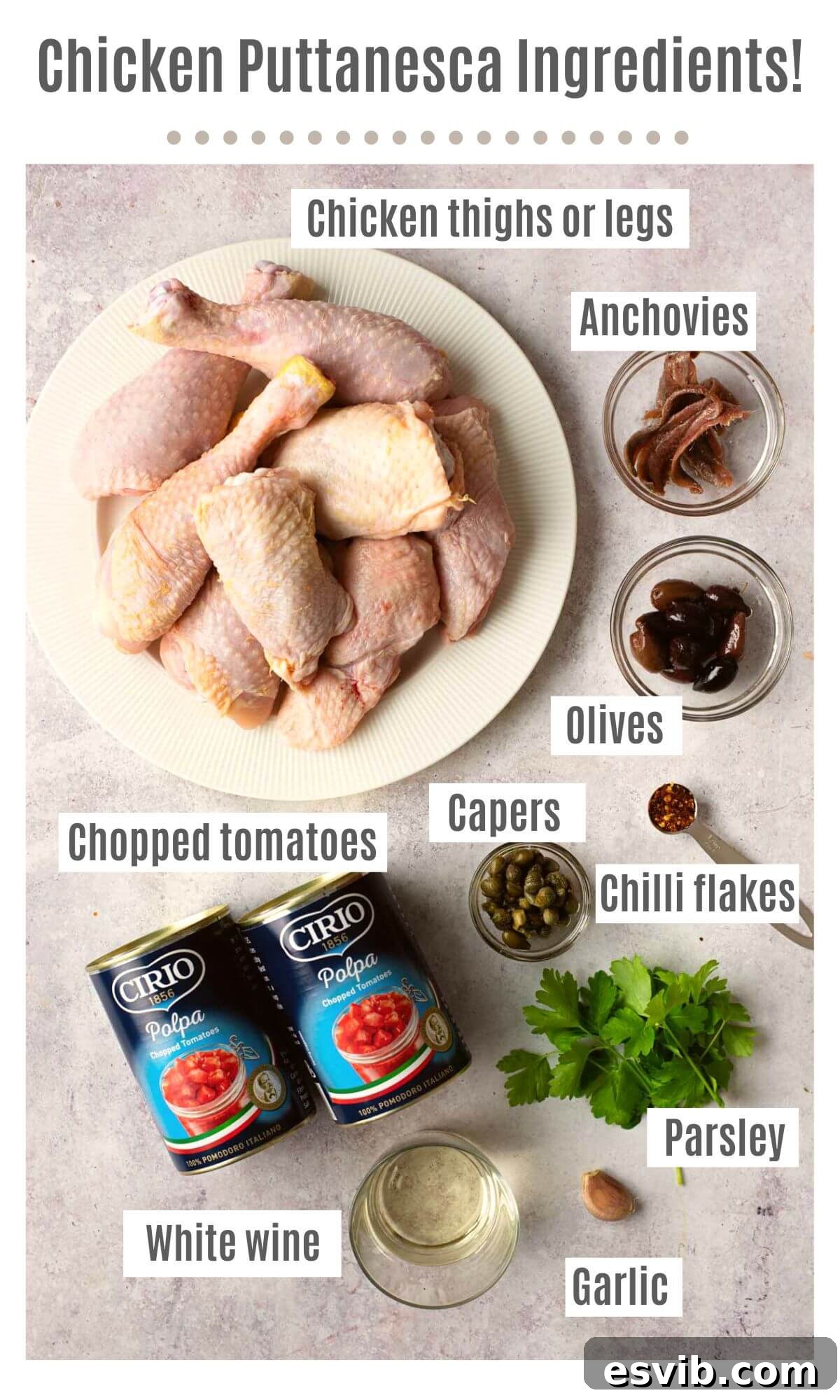 An overhead shot of labeled ingredients needed to make chicken puttanesca; including chicken thighs or legs, anchovies, olives, capers, chili flakes, chopped tomatoes, parsley, garlic, and white wine, neatly arranged on a white background.