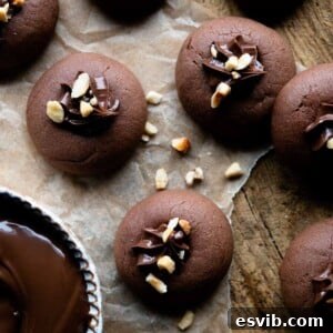 A cropped square image of perfectly baked Nutella cookies on a wooden surface, ready for filling.