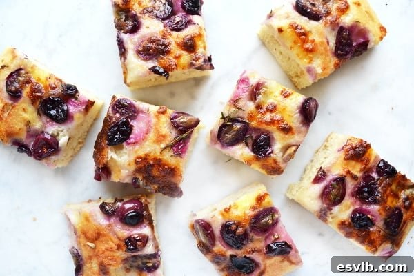 finished red grape and mozzarella focaccia, sliced and ready to serve, showing the roasted grapes and melted cheese