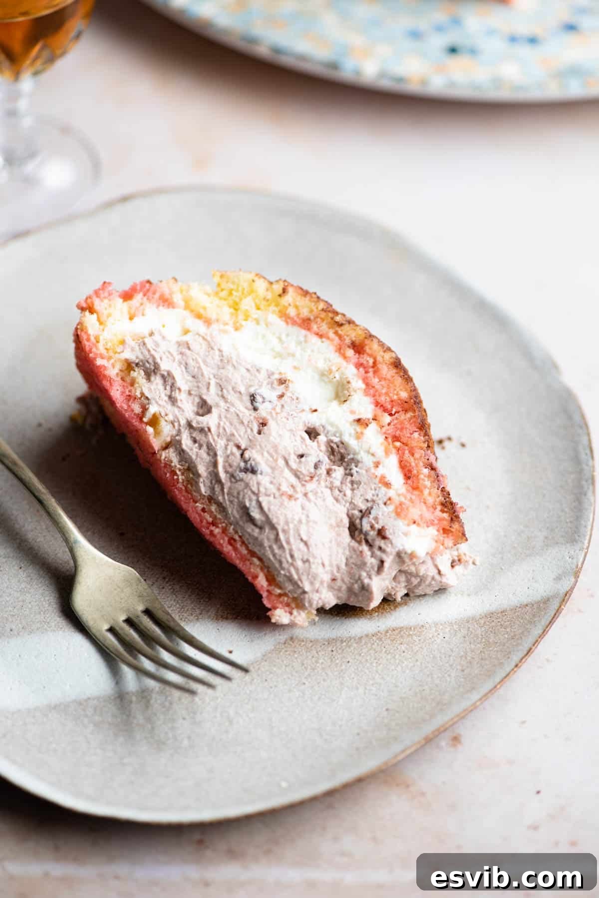 Zuccotto: Creamy Ricotta Sponge Cake 11 A perfectly portioned slice of Italian Zuccotto cake beautifully presented on a plate with a fork beside it, highlighting its creamy layers.