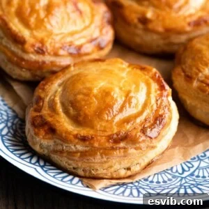 Rustic Lecce Tomato and Mozzarella Pastries 8 A close up of Rustici Leccesi on a blue plate, showcasing the flaky pastry and delicious filling.