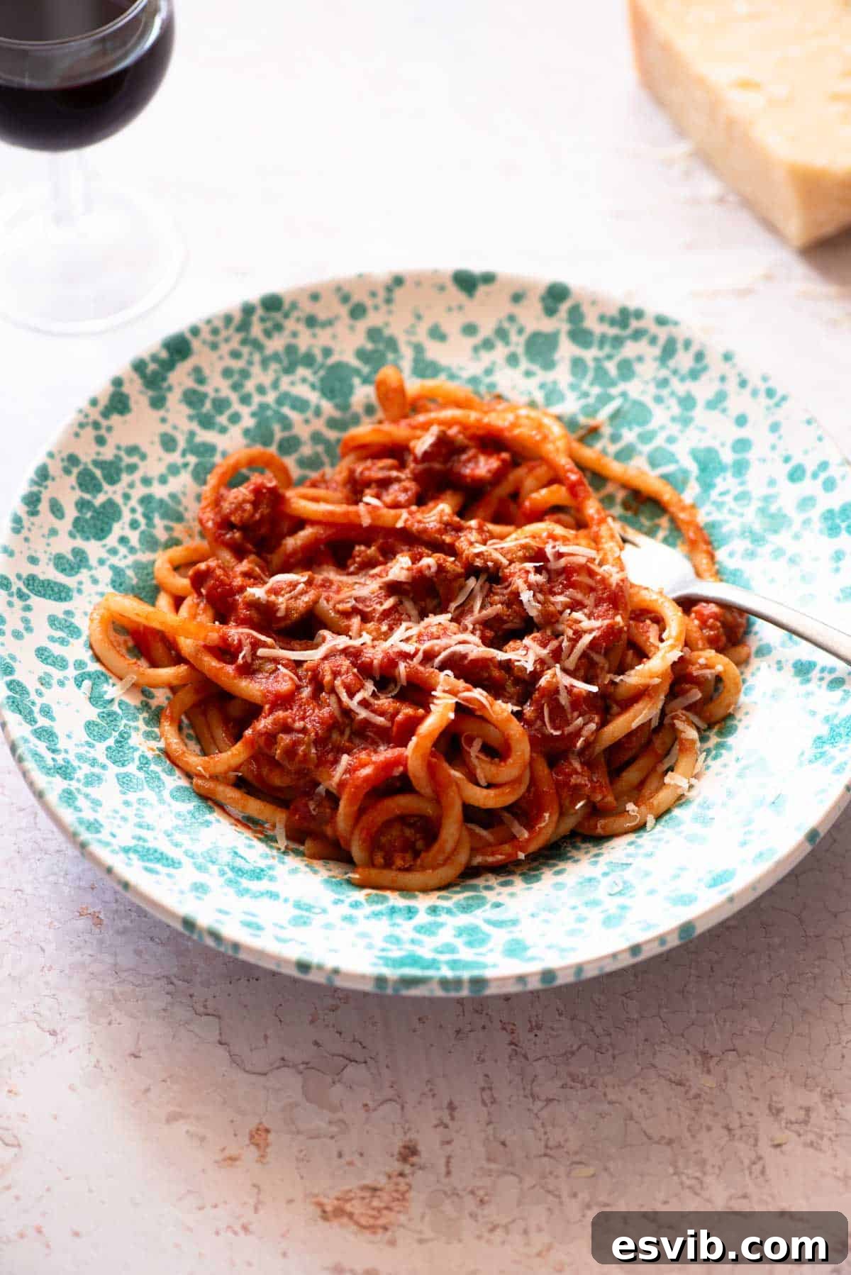 Rustic Tuscan Sausage Pasta 2 Tuscan sausage pasta with pici in a blue bowl on a light work surface.