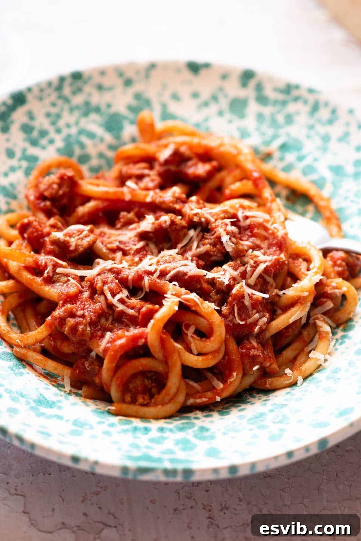 Rustic Tuscan Sausage Pasta 5 A close up of Tuscan sausage pasta in a blue bowl.