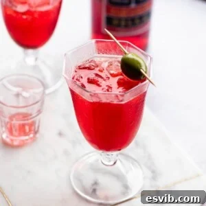 A cropped image of a Select Spritz on a marble surface garnished with a green olive.