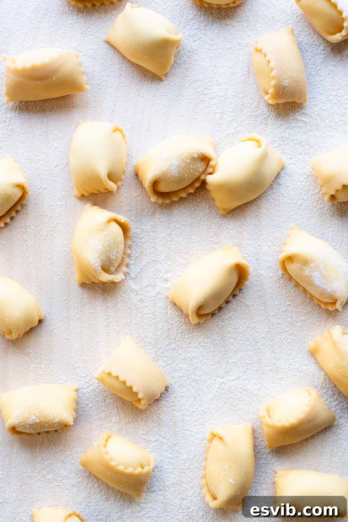 An inviting overhead shot of perfectly arranged Agnolotti pasta on a rustic wooden board, ready to be cooked or served.