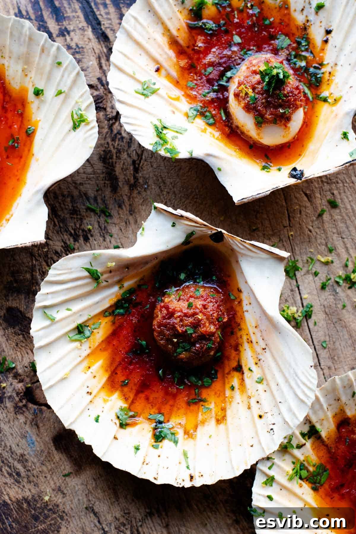 Seared Scallops with Fiery Nduja Garlic Butter 2 An overhead shot of perfectly seared scallops served in their shells, glistening with spicy 'Nduja garlic butter and a sprinkle of fresh gremolata.