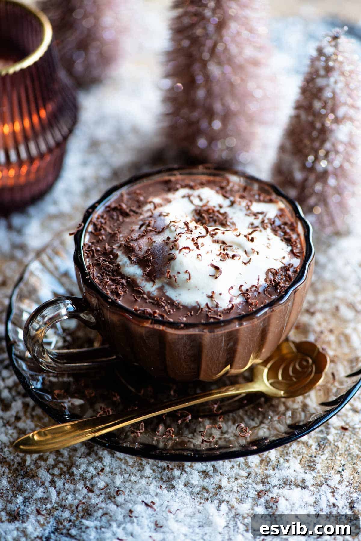 Decadent Frangelico Hot Chocolate Affogato 2 A glass mug filled with rich Frangelico Hot Chocolate Affogato, topped generously with creamy vanilla ice cream, surrounded by fake snow for a festive winter ambiance.