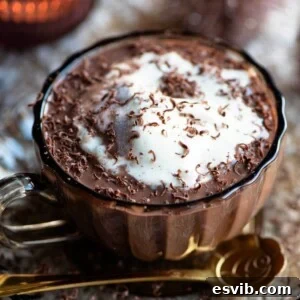 A close up of a hot chocolate affogato topped with vanilla ice cream in a glass mug, visually representing the recipe.