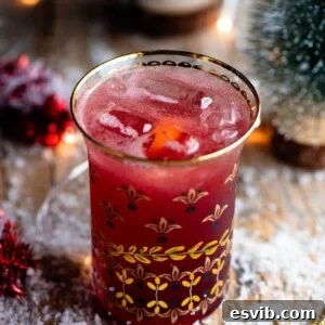 A close up of a Christmas Cocktail made of Cranberry juice and Prosecco in a gold glass, ready for a toast.