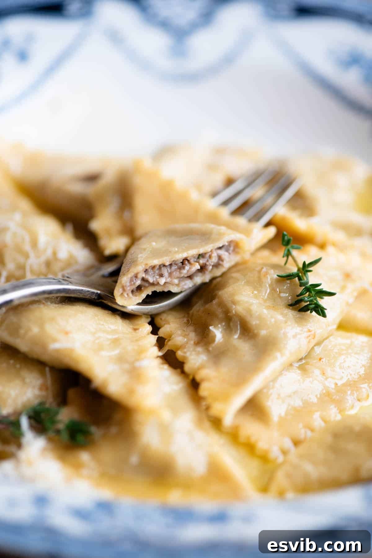 A close-up side view of delicious mushroom and Taleggio Triangoli pasta, with one piece expertly cut open to reveal the rich, creamy filling inside.