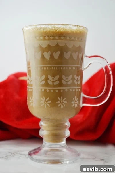 Homemade Banana Milk Coffee - Simple and Delicious Banana milk coffee in an elegant glass mug placed on a clean white surface, highlighting its creamy texture.