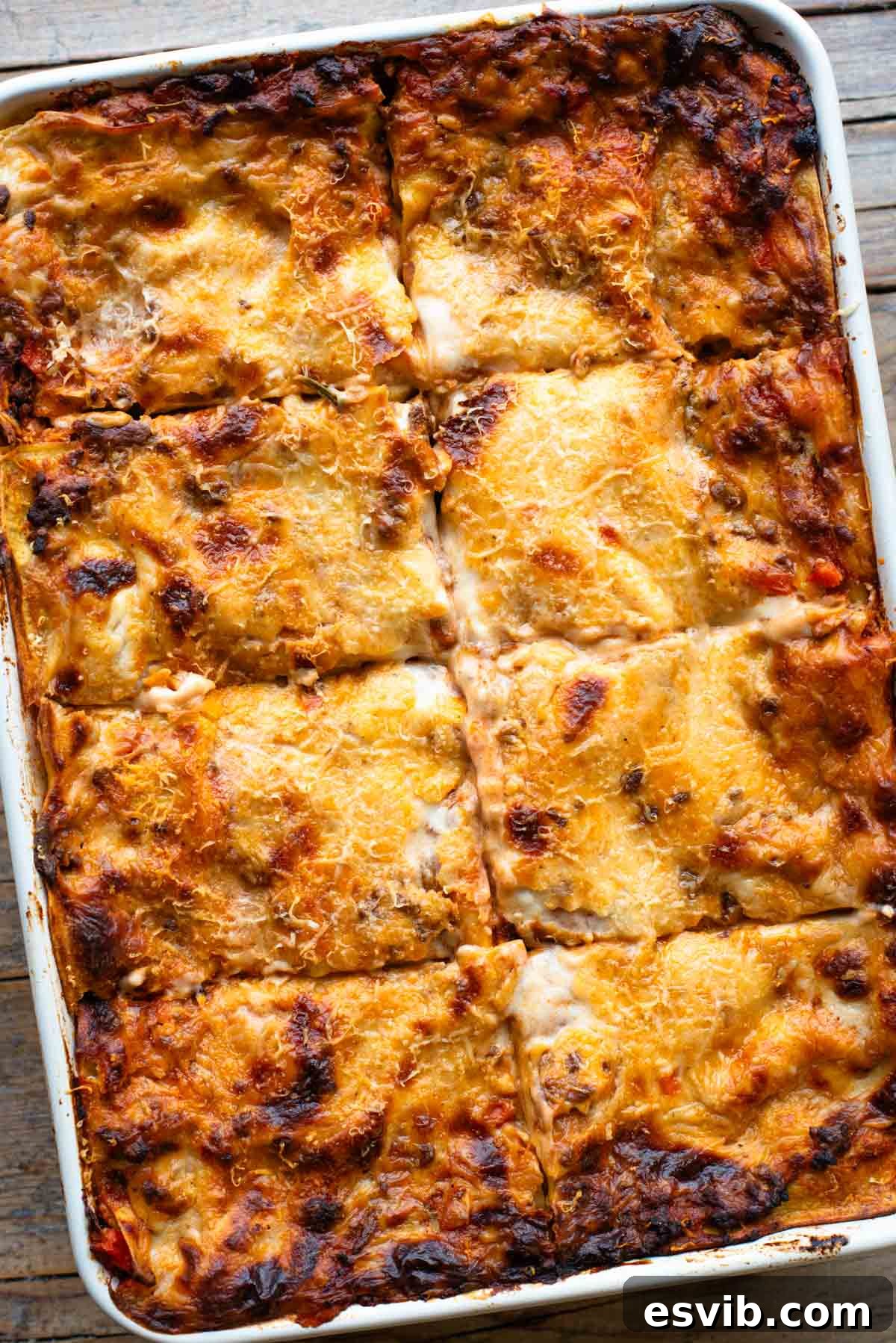 Lamb Ragù Lasagna with Pecorino Bechamel 14 An overhead shot of a large baking dish filled with a beautifully baked lamb lasagna, neatly cut into 8 enticing pieces, ready for serving.