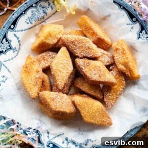 A square image of Crema Fritta (fried custard bites) in a bowl sitting on a wooden surface, beautifully presented.