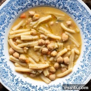An overhead shot of a delightful bowl of Pasta e Ceci (pasta and chickpeas), a comforting Italian soup, presented in a blue bowl.