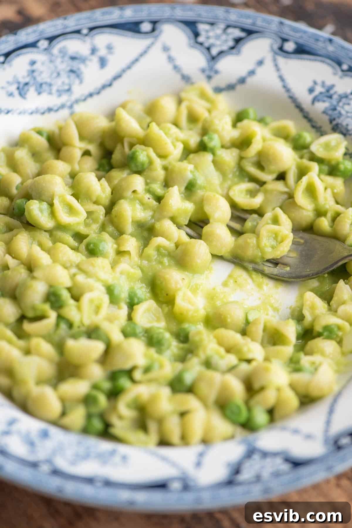 Spring Pea Pasta 7 A side shot of pasta and peas in a blue patterned bowl with a fork, showing the rich, creamy texture.