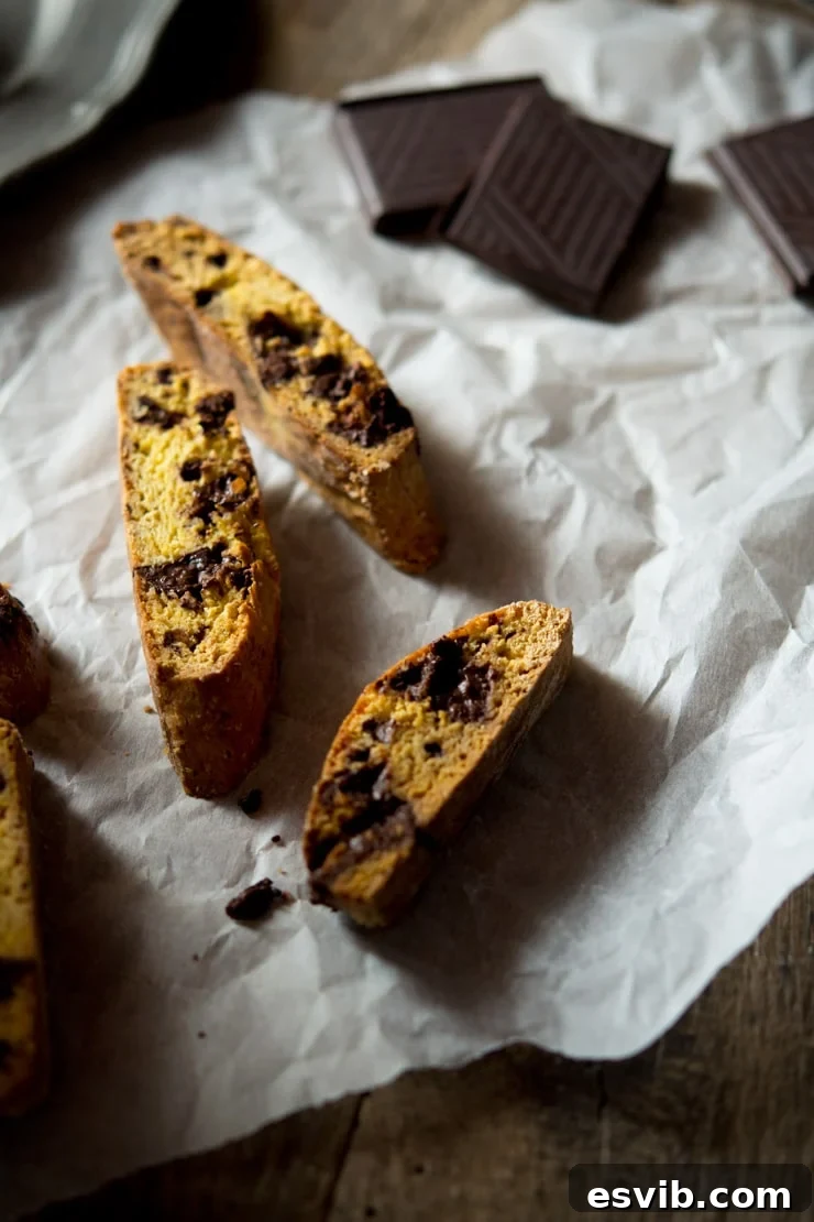 Platter of freshly baked orange chocolate cantucci biscuits, some whole, some sliced, showcasing their rich color and inviting texture. An easy Italian cookie recipe for all skill levels.