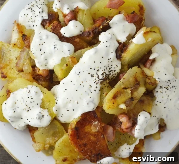 Bratkartoffeln, crispy fried potatoes with smoked pancetta and sweet white onion topped with an incredible garlic and herb sauce. It's SO GOOD! Insidetherustickitchen.com Bratkartoffeln, crispy fried potatoes with smoked pancetta and sweet white onion topped with an incredible garlic and herb sauce. It's SO GOOD! Insidetherustickitchen.com