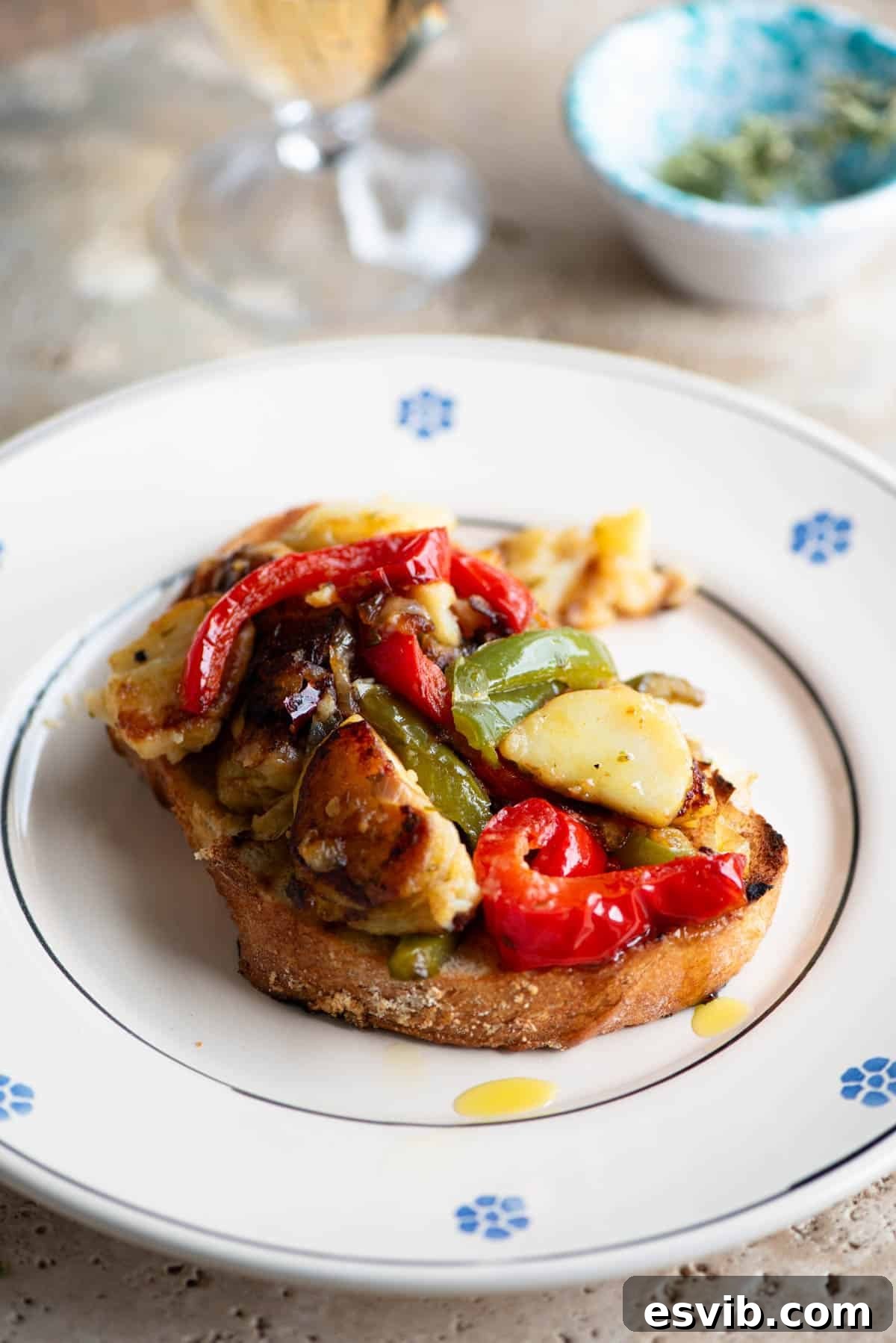Calabrian Pepper Potato Medley 5 A tempting side shot of Pipi e Patati served on a slice of rustic crusty bread, resting on a plate.