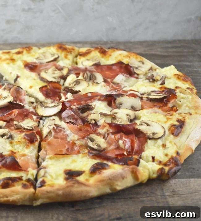 An insanely delicious Cheesy Speck and Mushroom Pizza recipe that is guaranteed to be your new favourite. www.insidetherustickitchen.com Close-up of a partially eaten slice of Cheesy Speck and Mushroom Pizza, showing the melted cheese and a crispy crust. The background is blurred, focusing on the delicious details of the pizza.