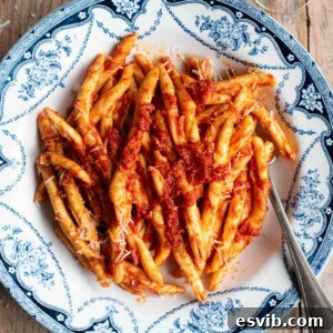 An overhead shot of a spicy tomato Nduja pasta in a blue and white bowl.