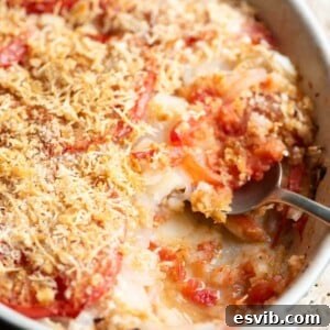 A close up cropped image of an Italian potato and tomato gratin with a golden, crispy topping.